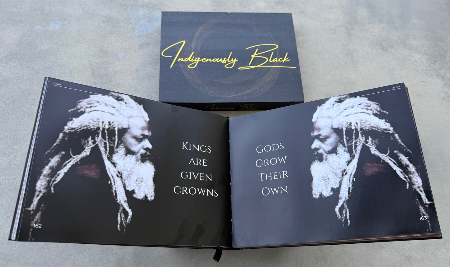 Open book with black and white illustrations and text on a gray surface, featuring the brand 'Indigenously Black'.