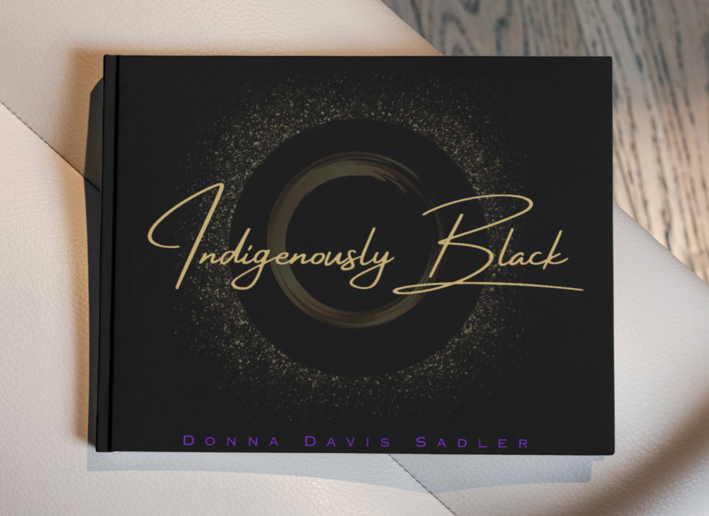 A coffee table book titled 'Indigenously Black' by Donna Davis Bassler, featuring a black cover with gold text and circular designs.